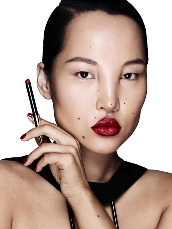 Model with red lips holding lipstick