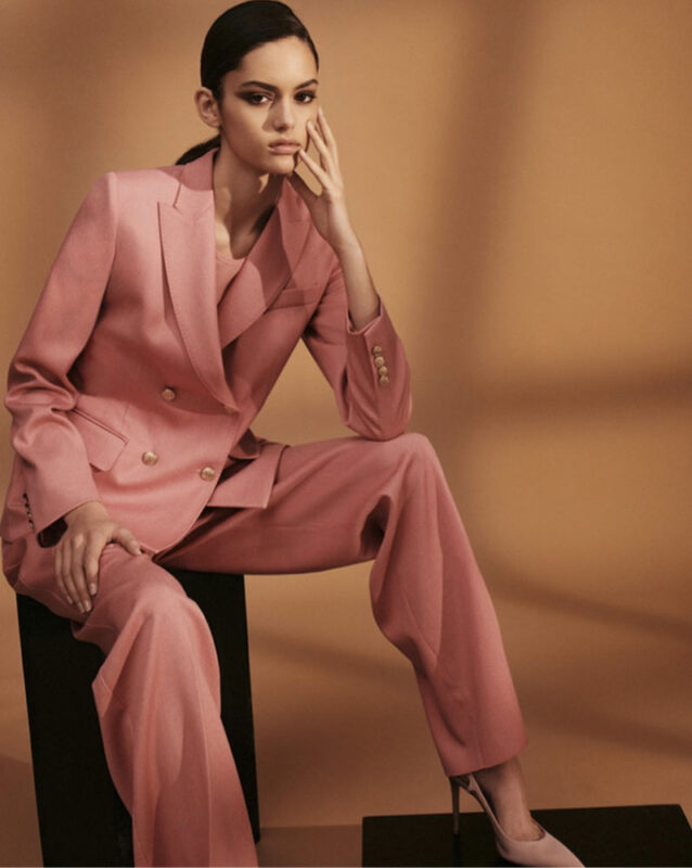 Model sitting down in a pink suit