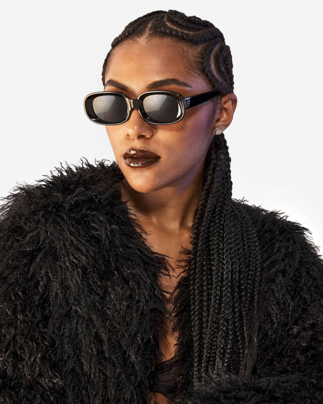 Model wearing a black coat wearing black sunglasses
