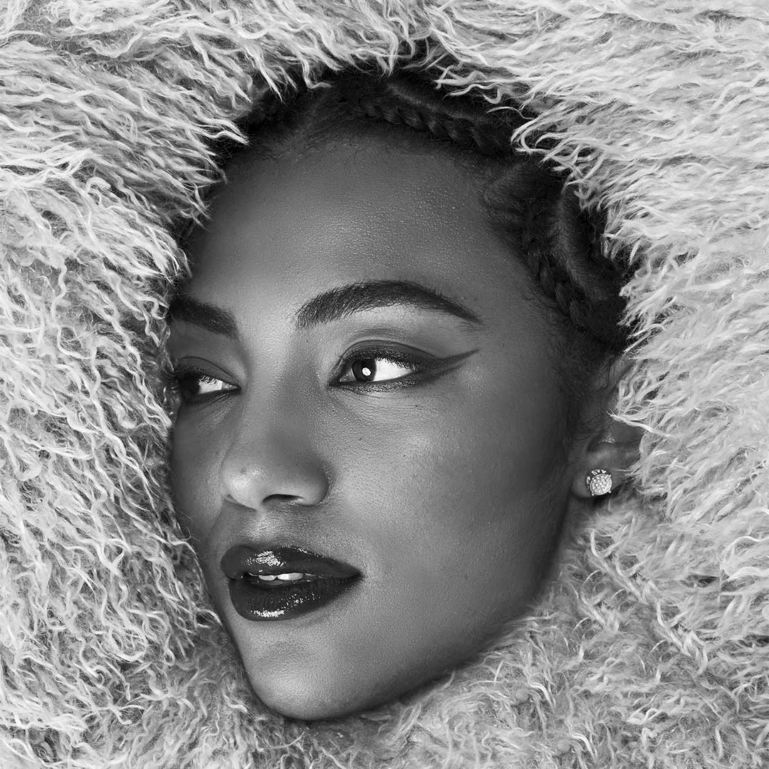 Model face surrounded by fluffed fabrics
