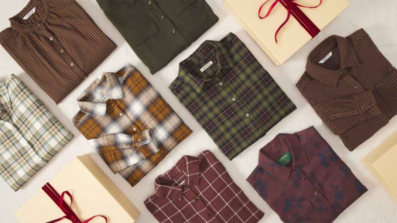assorted plaid button-up shirts laid out around gift boxes with ribbons on a light surface.